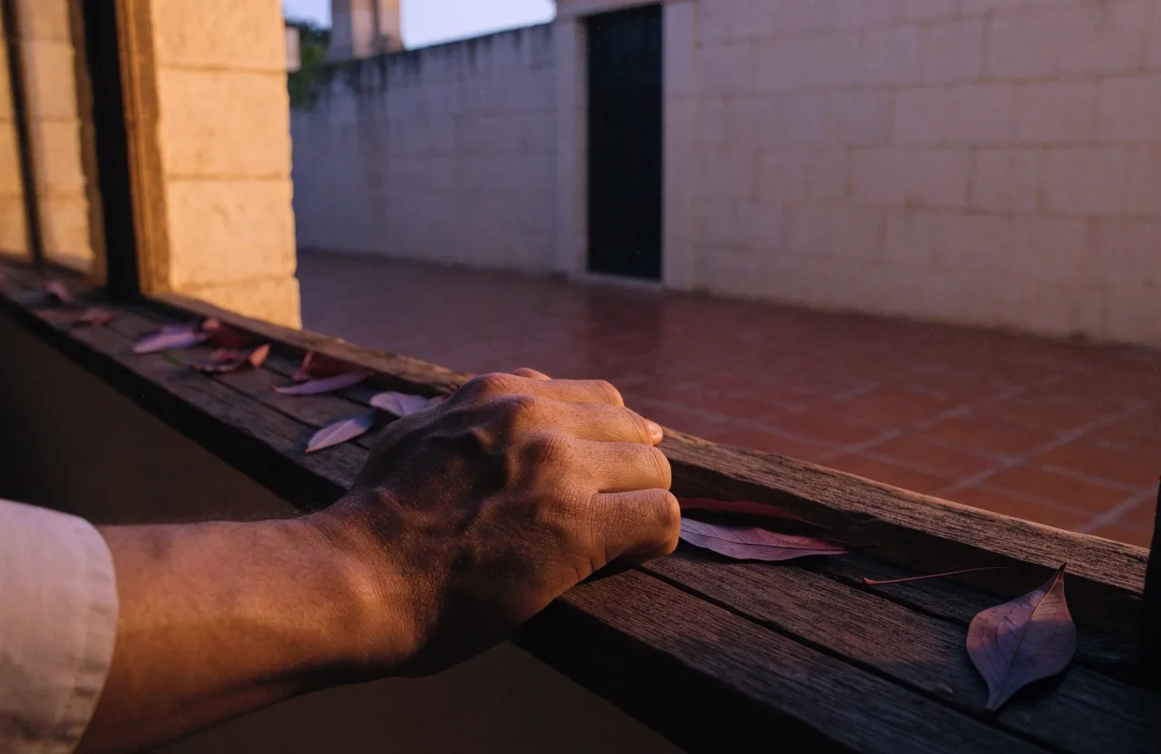 Patio de Mérida al anochecer visto desde una ventana, con luz cálida entrando por la izquierda